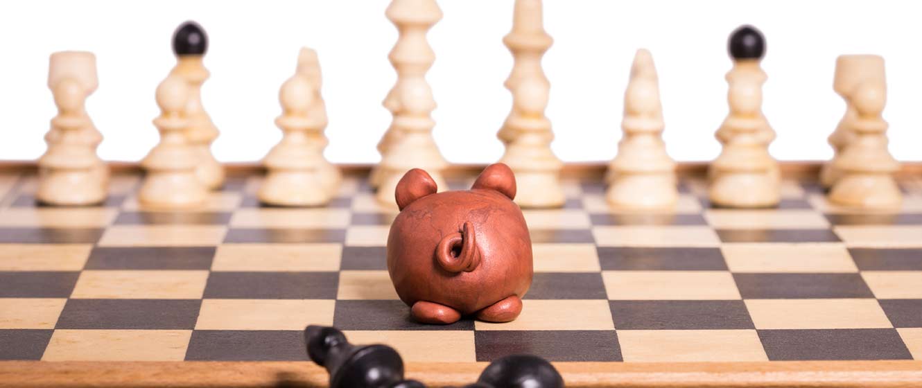 Image of chess set with piggy bank