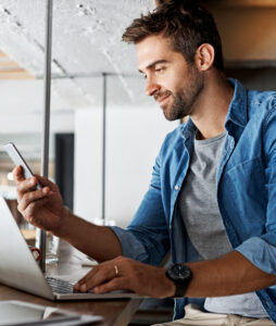 Man looking at mobile phone in a coffee shop