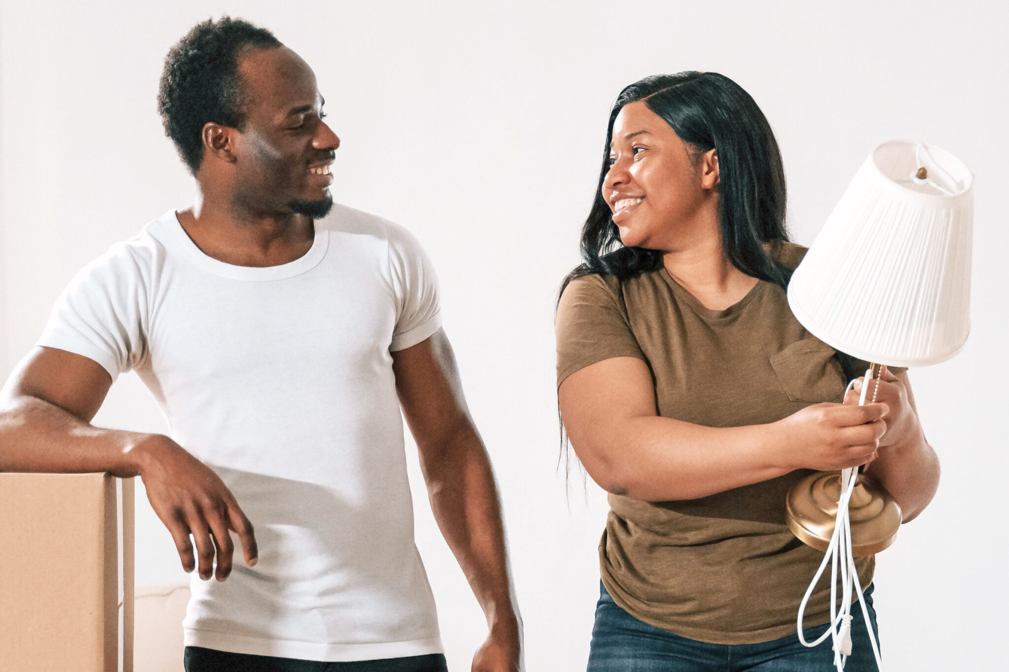 Smiling man and woman moving into a new house
