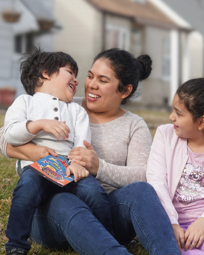 Smiling mother with children at home on the lawn