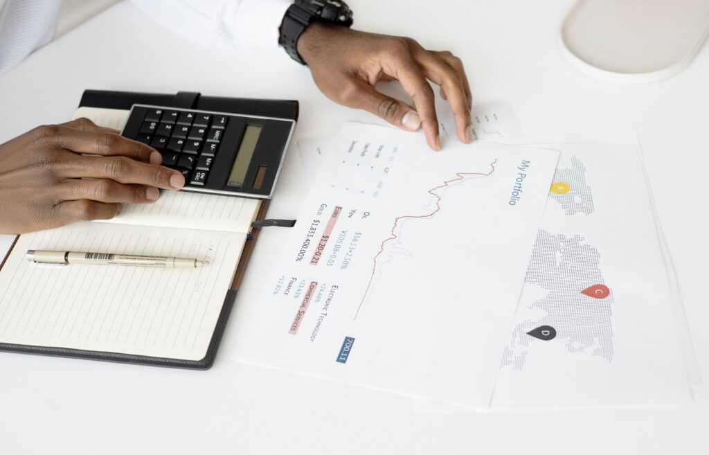 Overhead view of a person analyzing financial documents using a calculator for investment planning